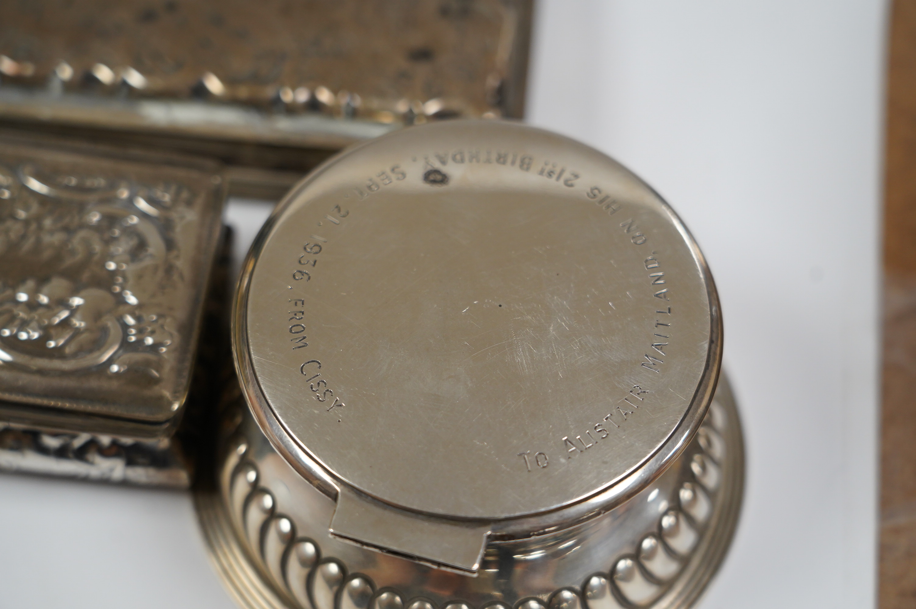 A late Victorian demi-fluted silver circular inkwell, with later engraved inscription, Birmingham, 1891, base diameter 11.4cm and two continental white metal boxes. Condition - poor to fair